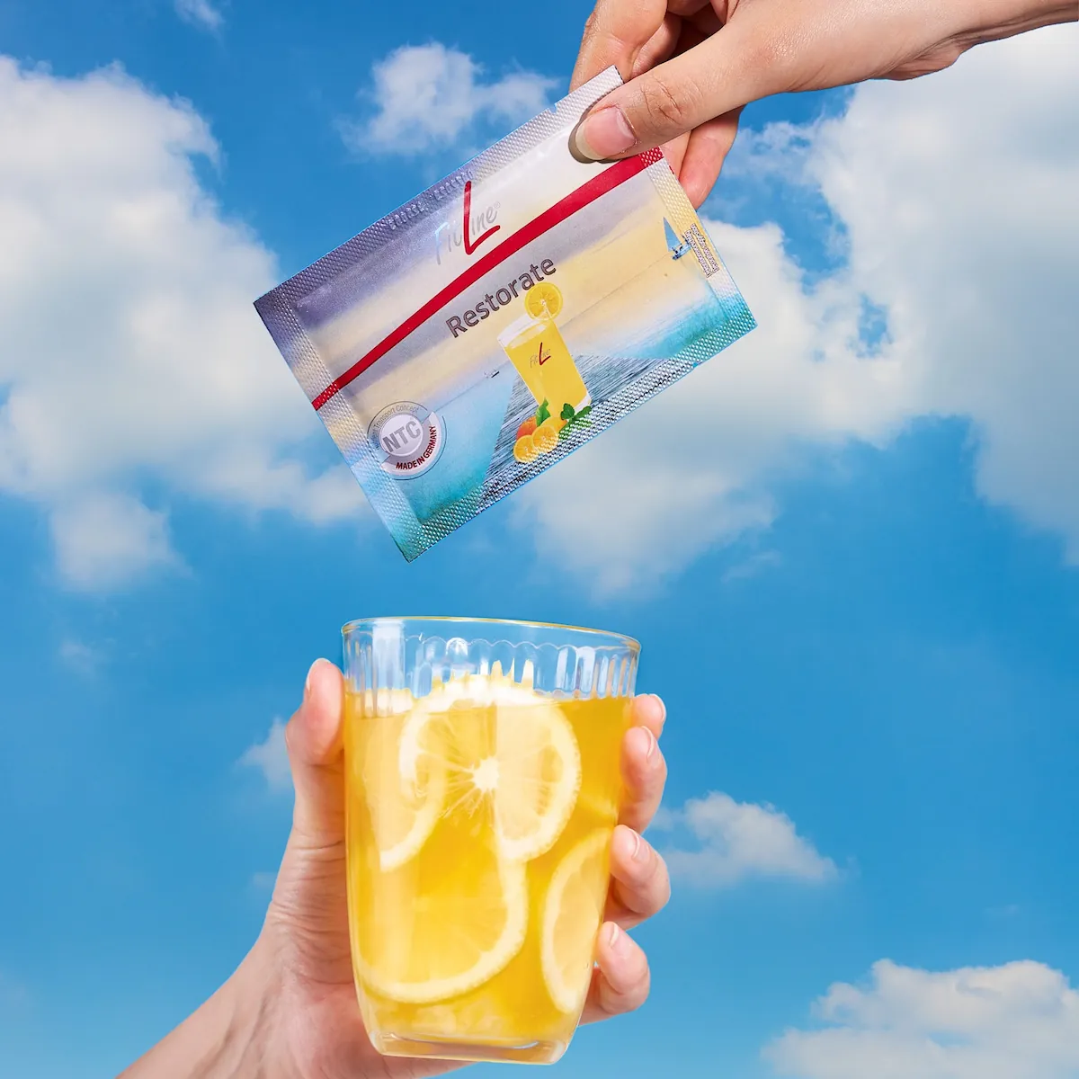 Préparation d’une portion de FitLine Restorate en ajoutant un sachet dans un verre d’eau.